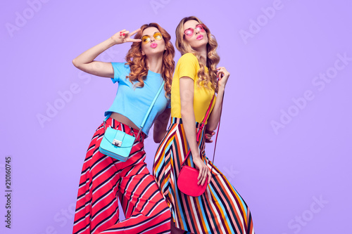 Photographie Two Playful Sisters Friends Jumping in Studio on Purple