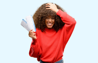 Poster - African american woman holding airline boarding pass tickets stressed with hand on head, shocked with shame and surprise face, angry and frustrated. Fear and upset for mistake.