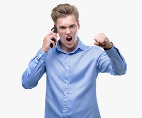 Canvas Print - Young handsome blond man using smartphone annoyed and frustrated shouting with anger, crazy and yelling with raised hand, anger concept