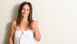 © Krakenimages.com - Beautiful middle age woman, wet hair wearing a towel pointing with hand and finger up with happy face smiling