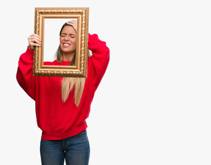 Poster - Beautiful young woman holding vintage frame stressed with hand on head, shocked with shame and surprise face, angry and frustrated. Fear and upset for mistake.