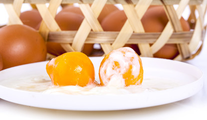 Two soft boiled eggs in the white bowl on the wooden table