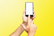 © Mayatnikstudio - Mockup of male hand holding frameless cellphone and swiping blank white screen isolated at yellow background.