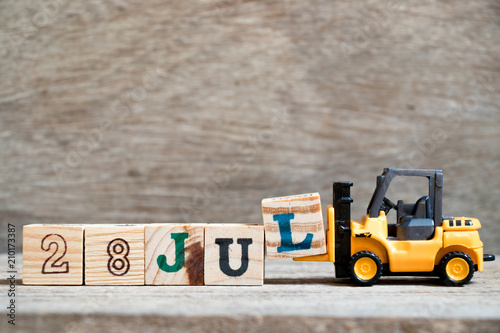 Poster Toy forklift hold block l to complete word 28 jul on wood background (Concept fo
