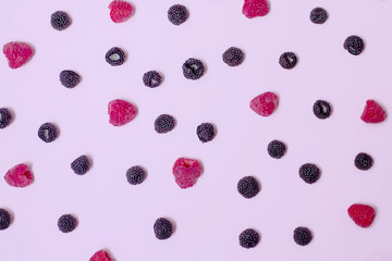 Wall Mural - .Pink background of summer seasonal berries. Black and red raspberries.