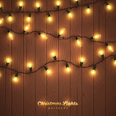 Wall Mural - Yellow christmas lights on wooden background