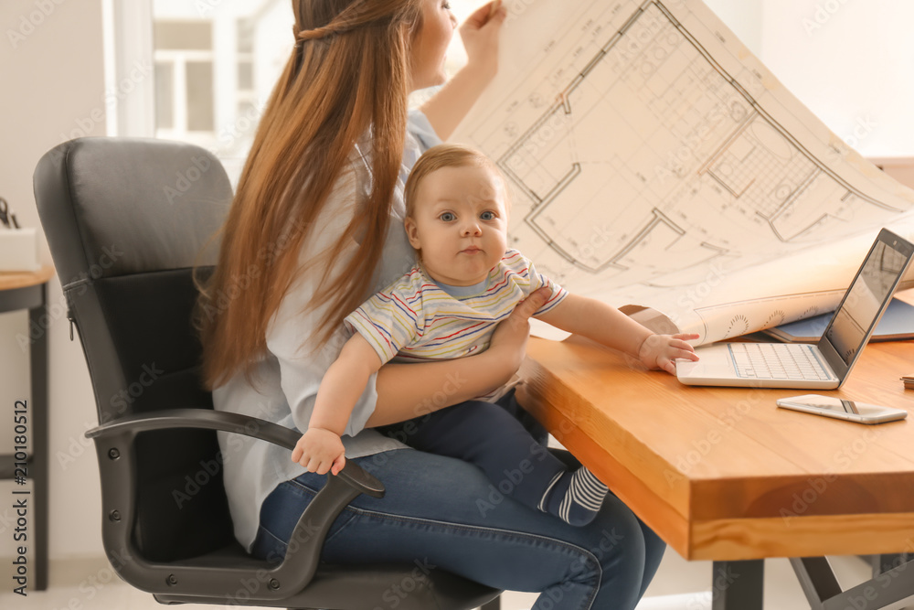 Young woman with baby working in office