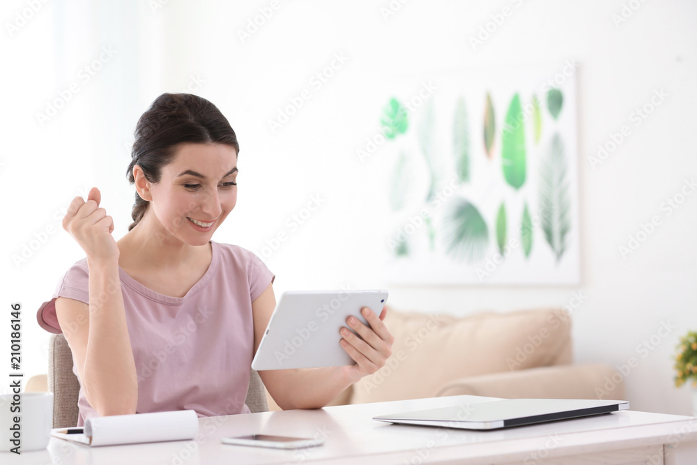 Young female freelancer working with tablet computer at home
