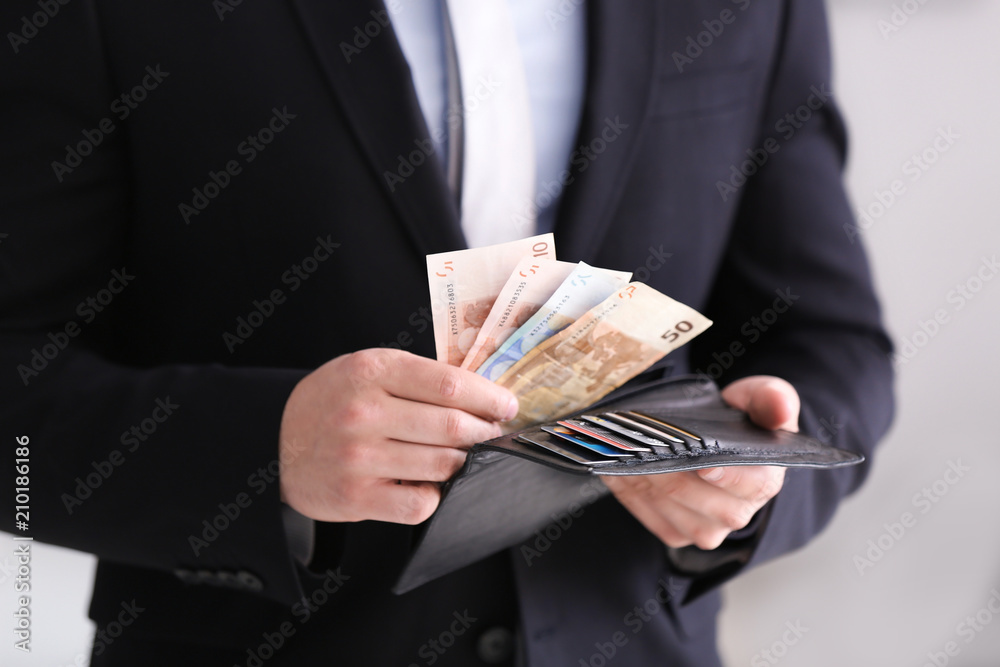 Young businessman counting money, closeup. Money savings concept