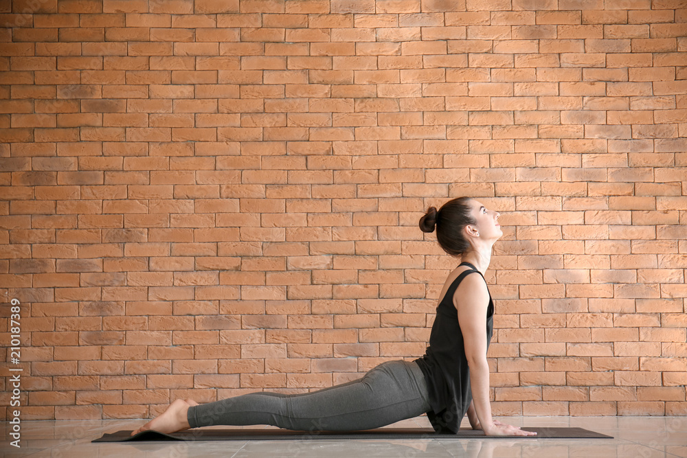 Young woman practicing yoga indoors