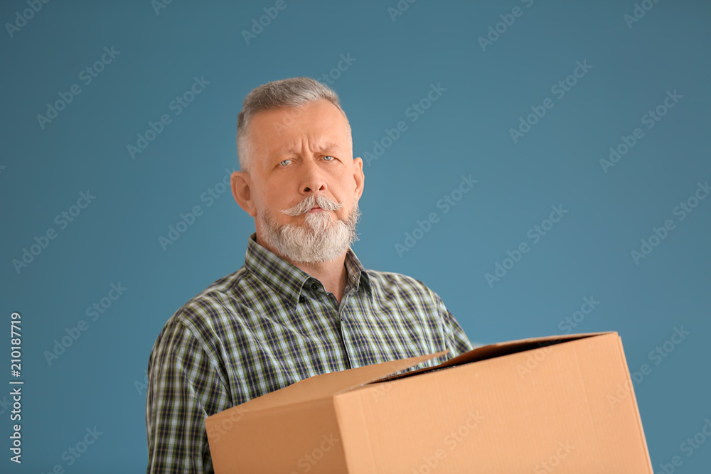 Mature man with moving box at new home