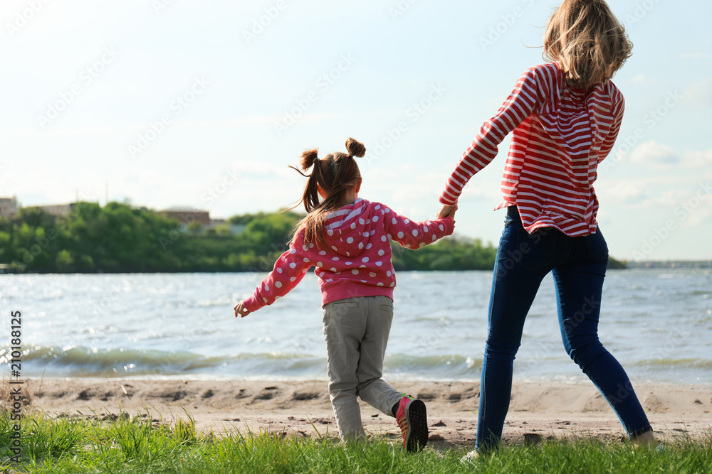 Little girl with mother near river