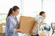 © Pixel-Shot - Young couple carrying box indoors. Moving into new house