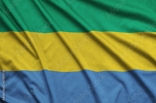 Fotografie, Obraz Gabon flag is depicted on a sports cloth fabric with many folds