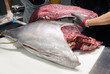 © Pixel-Shot - Men working with fresh tuna at table in fish market