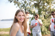 © Pixel-Shot - Young woman with friends at party on sunny day outdoors