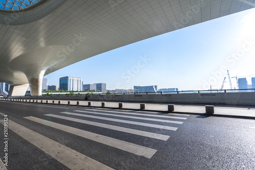 Cuadros en Lienzo asphalt road with modern office building in urban