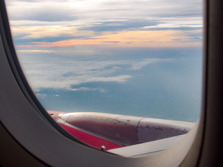 Sky and Clouds View from above through a window airplane at sunrise