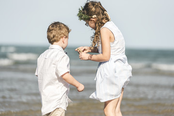 Wall Mural - Siblings having fun on the beach