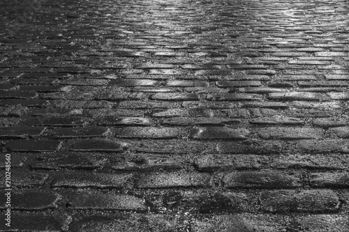 Cuadros en Lienzo Old wet illuminated cobblestone road on a rainy night