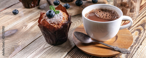 Muffins with blueberries and a cup of hot chocolate on a wooden background Tableau sur Toile