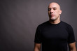 © Ranta Images - Handsome bald man against gray background