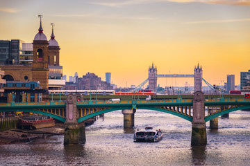 Orange sunset with London cityscape, including Southwark bridge, Cannon Street railway bridge and Tower bridge