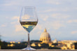 Glass of Italian white wine with St Peter's basilica, Rome, in the background