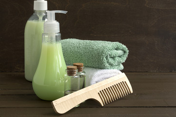 Liquid soap and two towels on a wooden background.