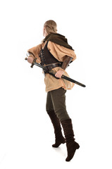 Poster - full length portrait of girl wearing medieval costume with sword. standing pose with back to the camera, isolated on white studio background.