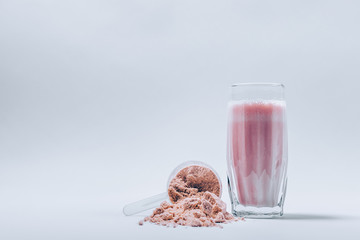 Wall Mural - Whey protein shake in a glass and overturned scoop