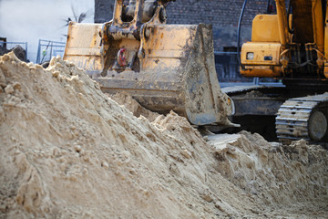 Excavator digs the earth. The excavator bucket rakes a handful of earth.