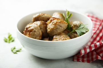 Wall Mural - Homemade meatballs with fresh parsley in a white bowl