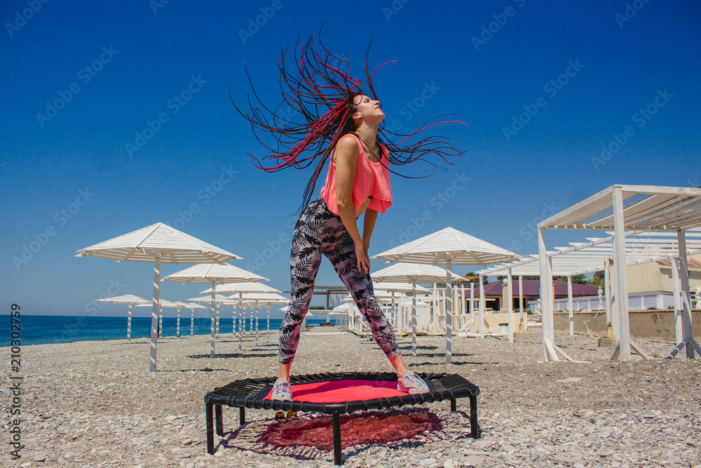 Photo Art Print A Slim Athletic With Dreadlocks Jumping On Photo Art Print A Slim Athletic With Dreadlocks Jumping On Fitness Trampoline Outdoors Pebble Beach By The Sea Abposters