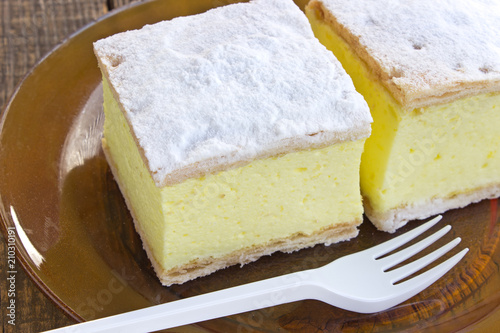 Fotografia, Obraz Cream pie with layers of puff pastry in plate on wooden table