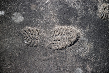 Shoeprint Imprinted On The Gray Asphalt.