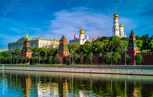 Plakat Moskwa Kremlin w porannych słoneczny poranek w lecie. Odbicie w rzece Moskwa. Lekkie białe chmury na niebieskim niebie.