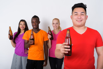 Wall Mural - Studio shot of happy young Asian man with diverse group of multi