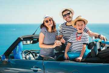 Happy family travel by car to the sea. People having fun in cabriolet. Summer vacation concept