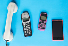 Technology Evolution Concept, Old And New Telephones On The Blue Background.