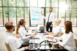 © rh2010 - A group of business people strictly dressed in white sitting together during a conference in the spacious office with flip chart on the green background