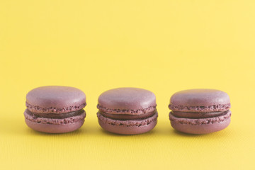 Wall Mural - Purple French Macarons on a Yellow Background