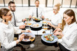 © rh2010 - Business people dressed in white shirts having fun sitting together during a business lunch with delicious meals and wine in the modern restaurant