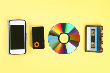 The concept of the evolution of music. Cassette, CD-disk, mp3 player, mobile phone. Vintage and modernity. Music support.