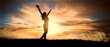 Free And Happy Woman Raises Her Arms At Sunset