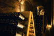 Pupitre and bottles inside an underground cellar for the production of traditional method sparkling wines in italy
