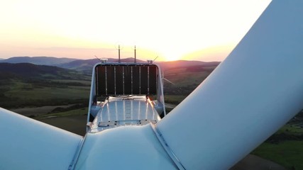 Wall Mural - close up view of wind turbine details over beautiful sunset on background aerial shooting forestry landscape on background village area sunny sky windmill farm electricity new technology healthy eco