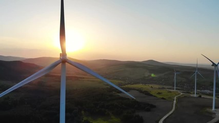 Wall Mural - aerial view of wind turbines converting wind energy into elecrticity with beautiful summer sunshine on the horizon green tourism eco business concept technology development human future windmill