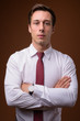 © Ranta Images - Young handsome businessman against brown background