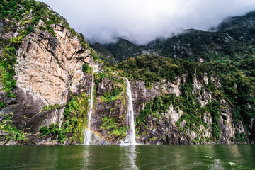 a stunning scene of nature with many waterfalls from the high mountain at milford sound, new zealand